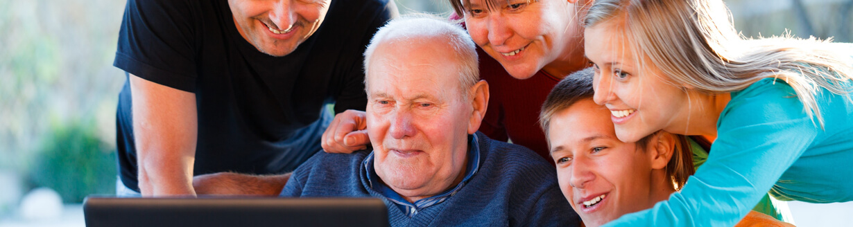 Family members of different ages looking at report on laptop computer